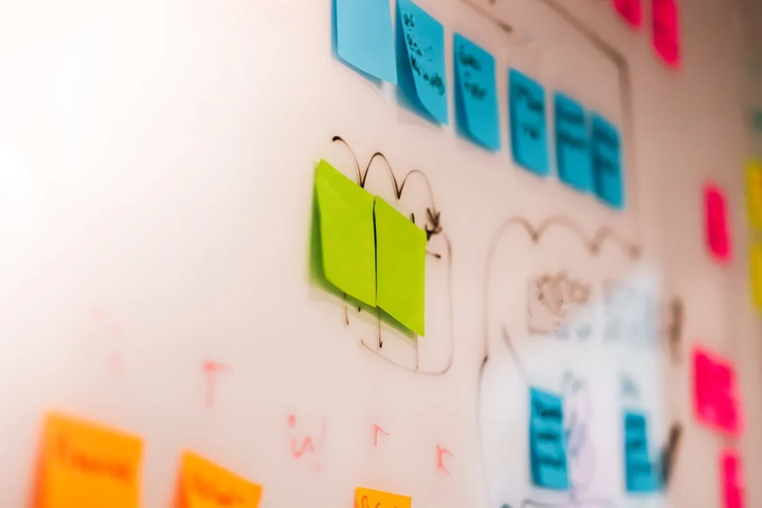 Une équipe variée travaillant ensemble sur des stratégies de marketing digital autour d’un bureau, avec des ordinateurs portables et des tablettes.